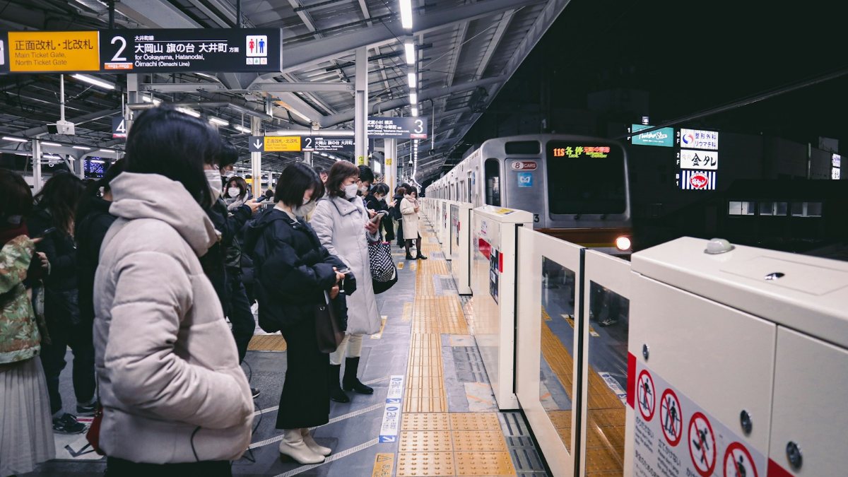 駅で電車を待つ人々のグループ