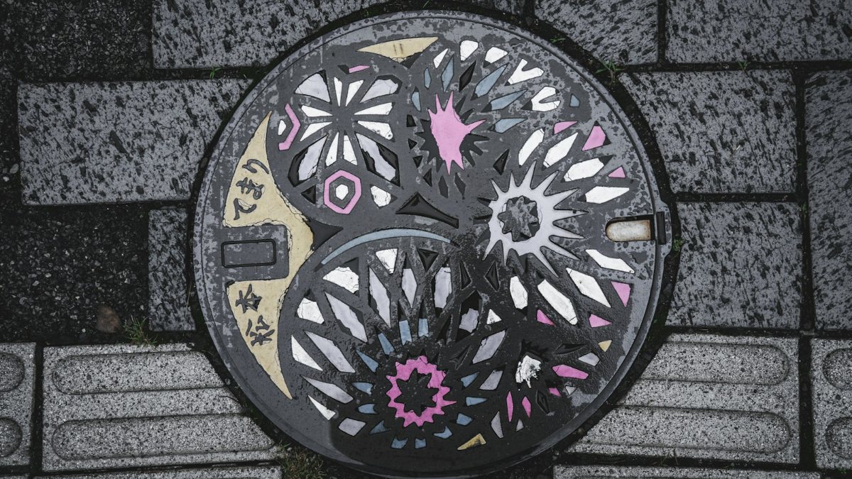 歩道に設置されたカラフルな花柄のマンホール