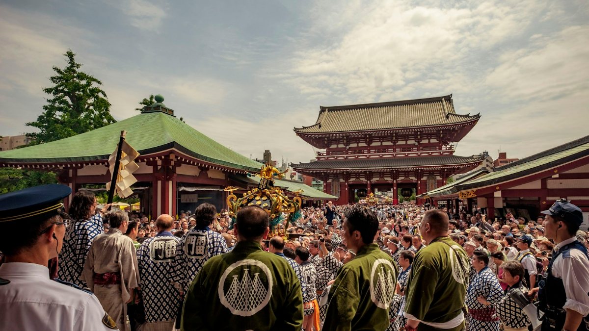 お寺の前に集まる人々のグループ