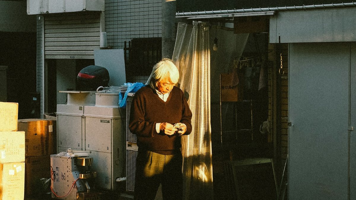 夕方の日本の通りを歩く高齢者