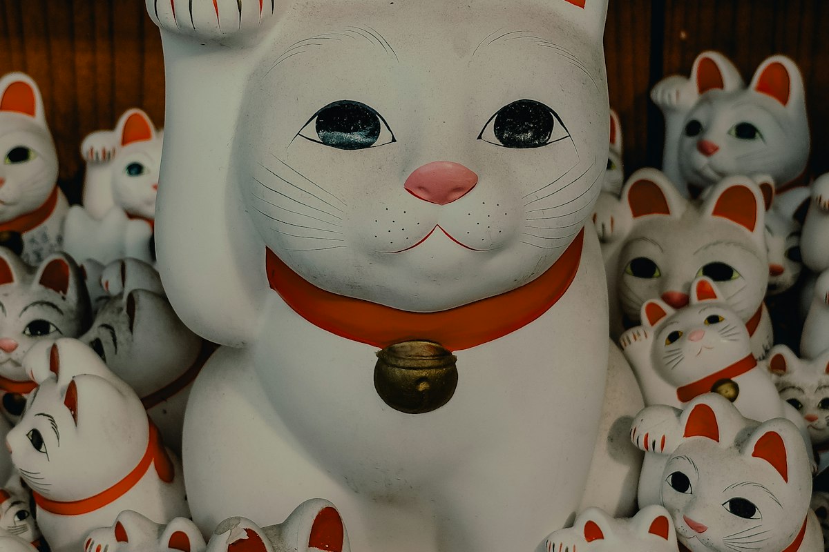 赤い首輪をつけた白い招き猫の置物